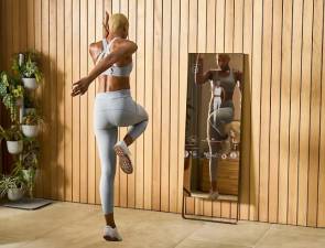 Frau macht Fitness vor interaktivem Spiegel 