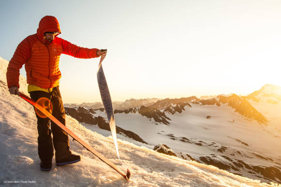 Mann bringt Skifelle an im Gebirge 