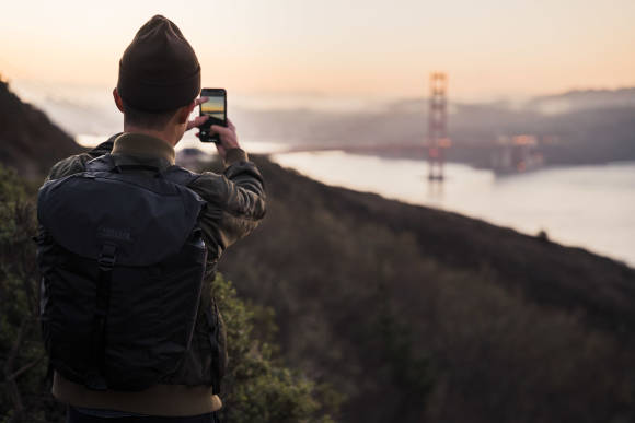 Mann fotografiert mit Handy die Golden Gate Bridge 