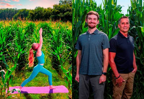 Männer und Frau in Yoga-Pose hinter Mais 