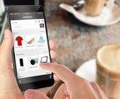 Online-Shopping mit Smartphone. Schreibtisch mit Kaffee im Hintergrund. 