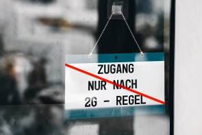 durchgestrichenes 2G-Schild an Ladentür 