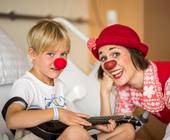 Kind und Frau mit Clownsnasen im Krankenhaus