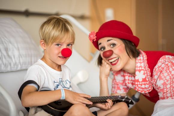 Kind und Frau mit Clownsnasen im Krankenhaus 