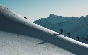 Menschen beim Tourengehen in den Alpen im Schnee 