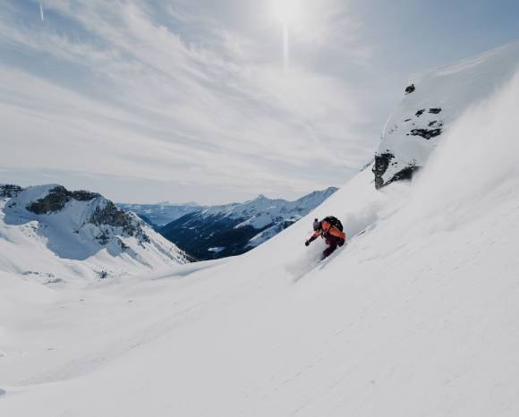 Skifahrer bei Abfahrt im Schnee 