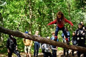 Mädchen balanciert über Baumstamm 