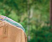 Shirts aus Naturmaterialien hängen auf Kleiderbügeln