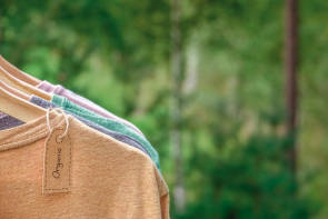 Shirts aus Naturmaterialien hängen auf Kleiderbügeln 