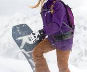 Frau mit Snowboard im Schnee