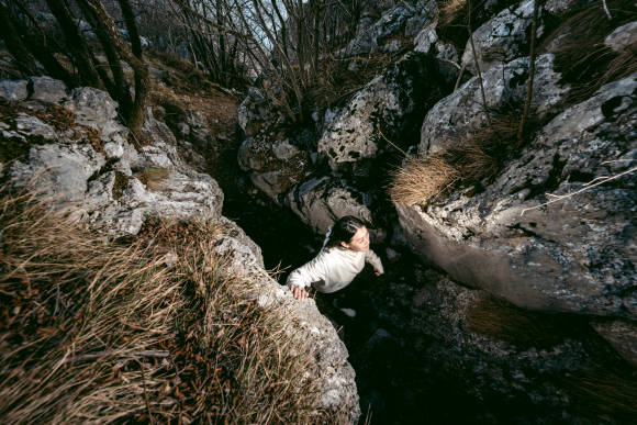 Frau läuft durch enge Felsenschlucht 