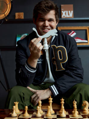 Magnus Carlsen hält Schachfigur mit Puma-Logo 
