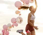 Frau läuft mit vielen Luftballons