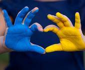 eine blaue und eine gelbe Hand formen ein Herz