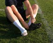 Fußballer zieht Socken an