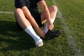 Fußballer zieht Socken an 