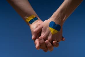 Zwei gefasste Hände mit der Ukraine-Flagge 