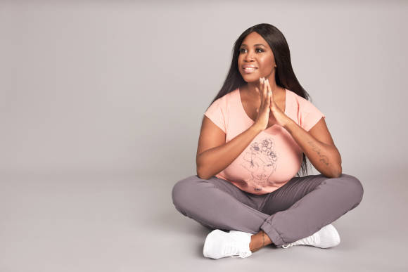 Motsi Mabuse sitzend in Fitnesskleidung 