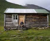 Frau ruht sich vor Berghütte aus