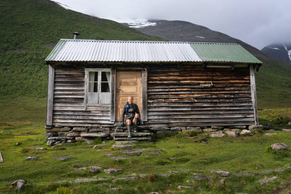 Frau ruht sich vor Berghütte aus 