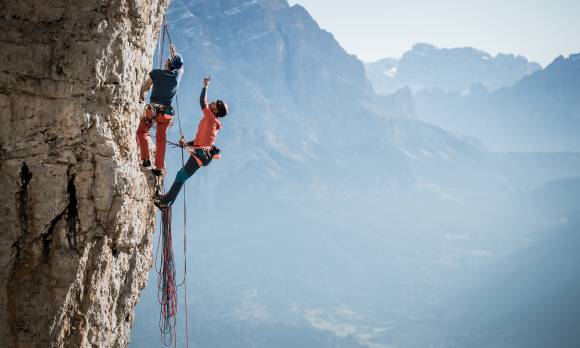 zwei Menschen klettern am Fels im Gebirge 