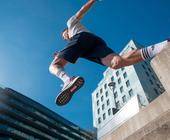 Mann springt mit Adidas-Sportschuhen in der Stadt