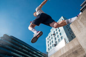 Mann springt mit Adidas-Sportschuhen in der Stadt 