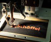 Stickereimaschine stickt Schöffel-Logo