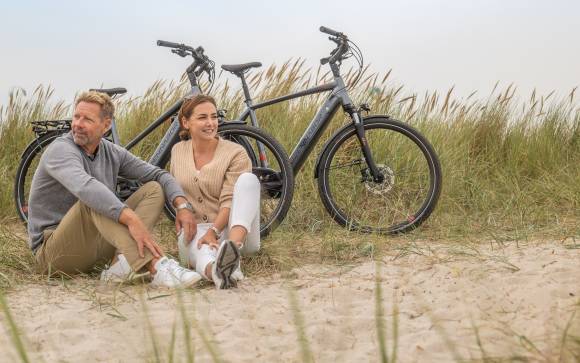 Zwei Personen vor sitzen vor einem Fahrrad 