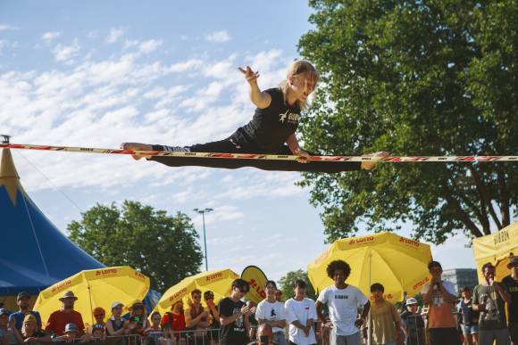 Junge Athletin im Spagat auf einer Slackline 