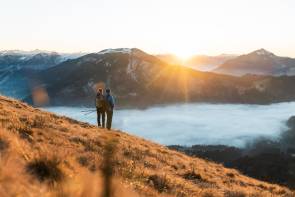 zwei Menschen beobachten den Sonnenaufgang in den Bergen 