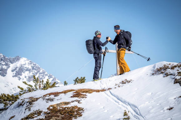 Zwei Bergsportler auf einem Gipfel 