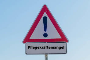 Warnschild mit der Aufschrift Pflegekräftemangel 