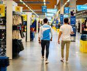 Decathlon-Mitarbeiter läuft durch Filiale mit Kunden