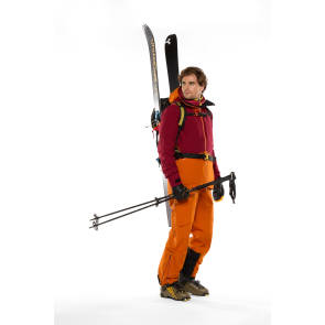 Wintersportler in orangener Skihose und roter Skijacke