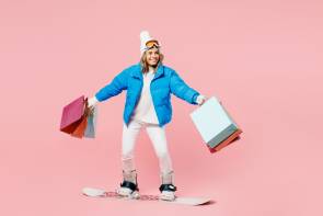 Frau auf Snowboard mit vielen Einkaufstüten 