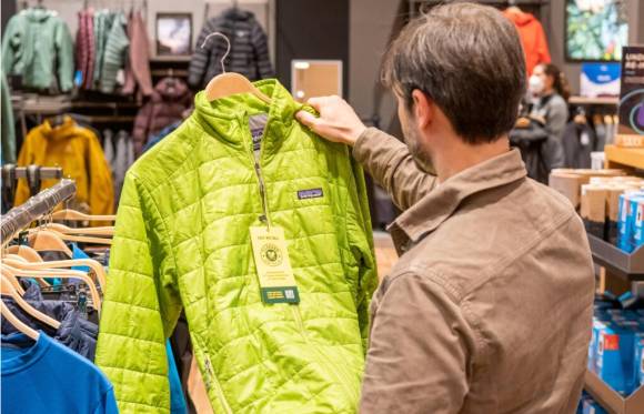 Mann schaut Secondhand-Jacke an 
