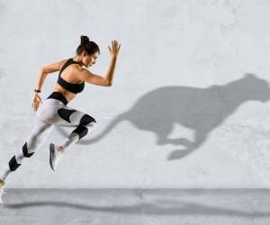 Frau rennt, im Hintergrund Schatten eines Pumas