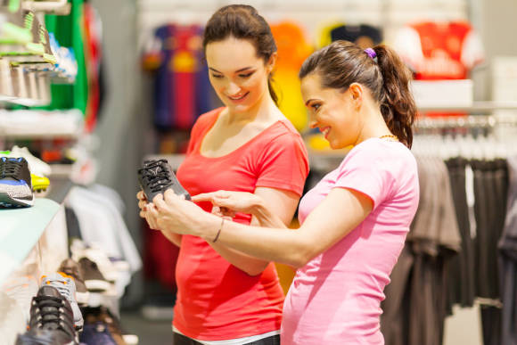 zwei Frauen schauen im Shop Sportschuhe an 