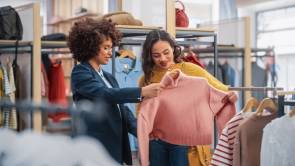 zwei Frauen schauen Pulli im Modeshop an 