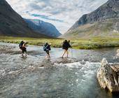 Menschen überqueren Fluss im Gebirge