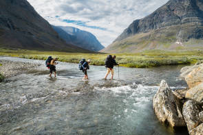 Menschen überqueren Fluss im Gebirge 