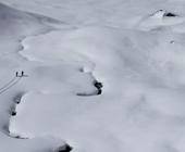 Schneelandschaft im Gebirge mit zwei Skitourengehern