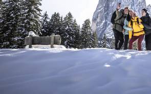 Vier Personen vor einem Berg im Schnee 