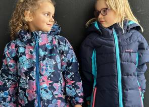 Zwei Kinder, die Kamik-Jacken tragen 