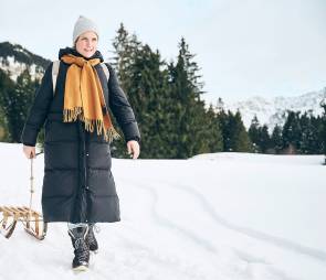 Person mit Schlitten im Schnee 