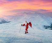 Weihnachtsmann mit Wanderstöcken im verschneiten Gebirge