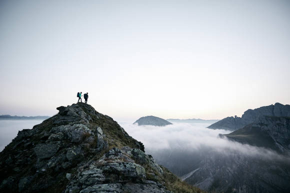zwei Menschen auf Berggipfel 