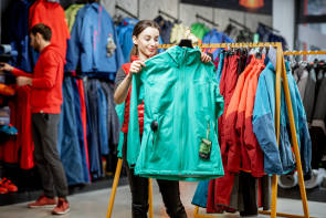 junge Frau im Store schaut sich Skibekleidung an 