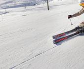 Eine skifahrende Person auf der Piste.